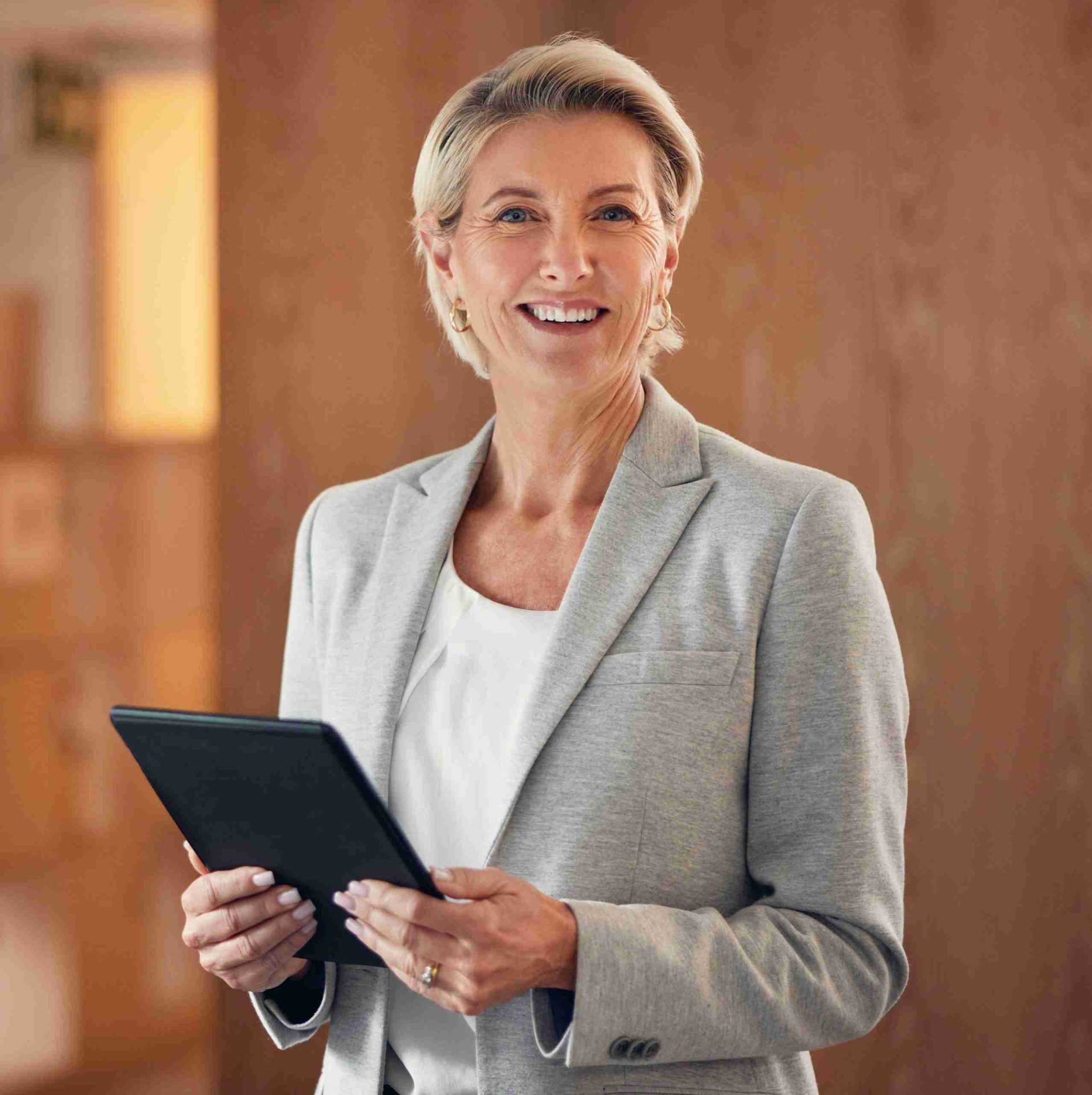A law professional smiles eagerly holding a tablet with information.
