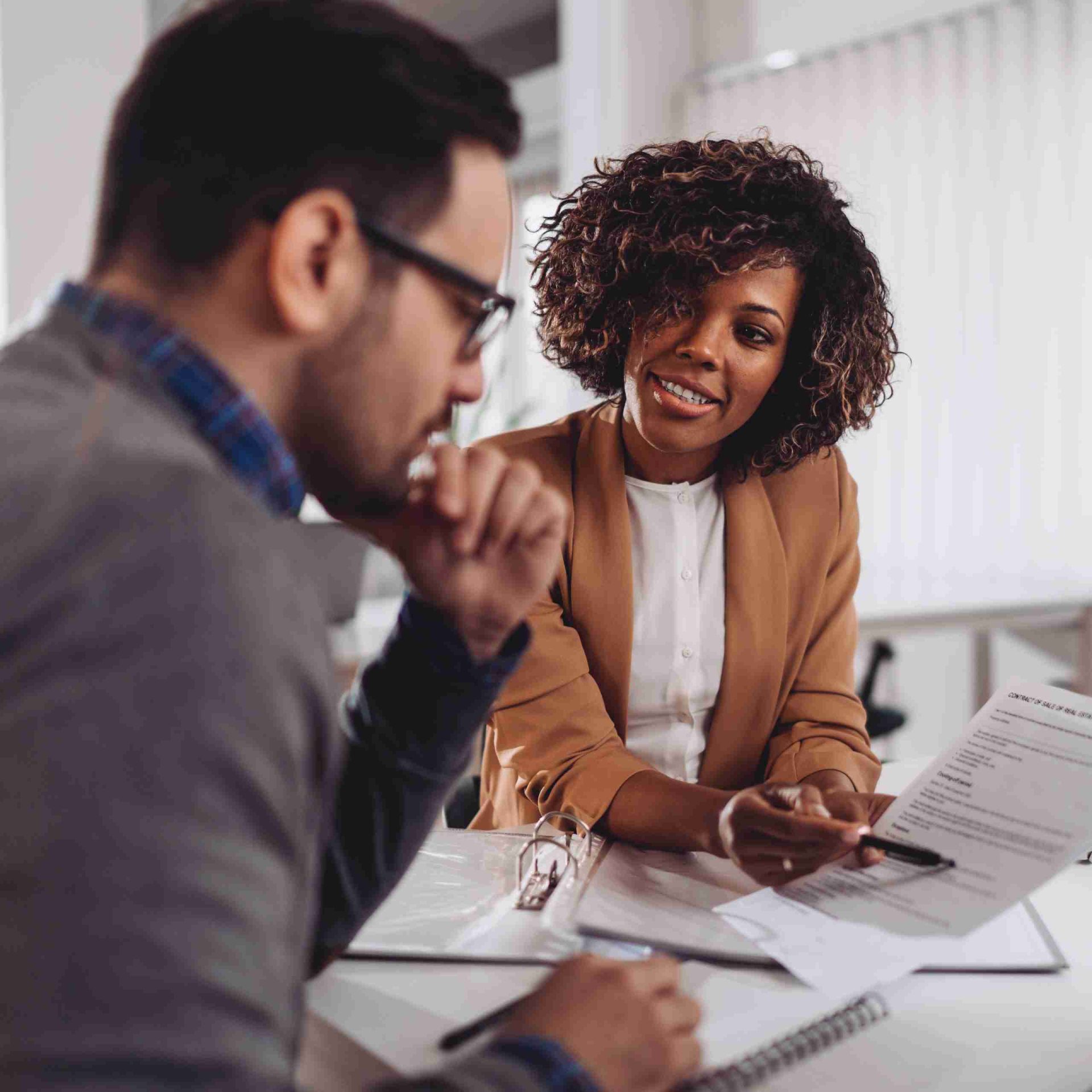 Two law professionals discuss some documents.